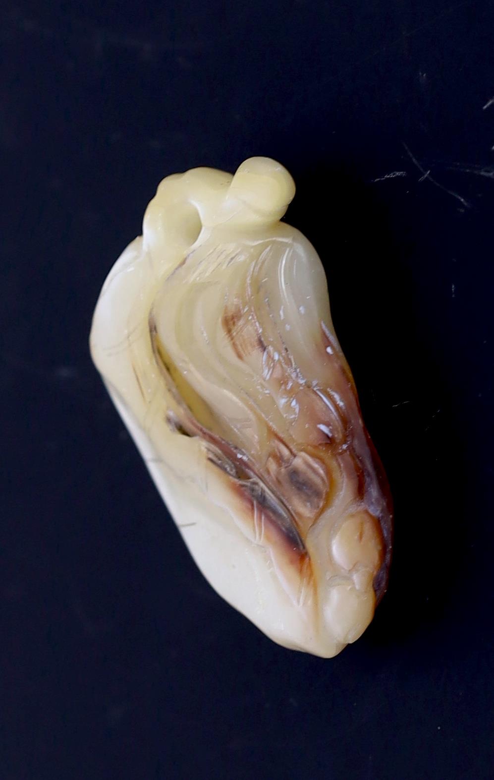 A Japanese mother of pearl netsuke of a leaf and berries, ridden by a bat and a spider, Meiji period